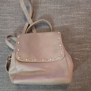 Tan backpack with pearl accents